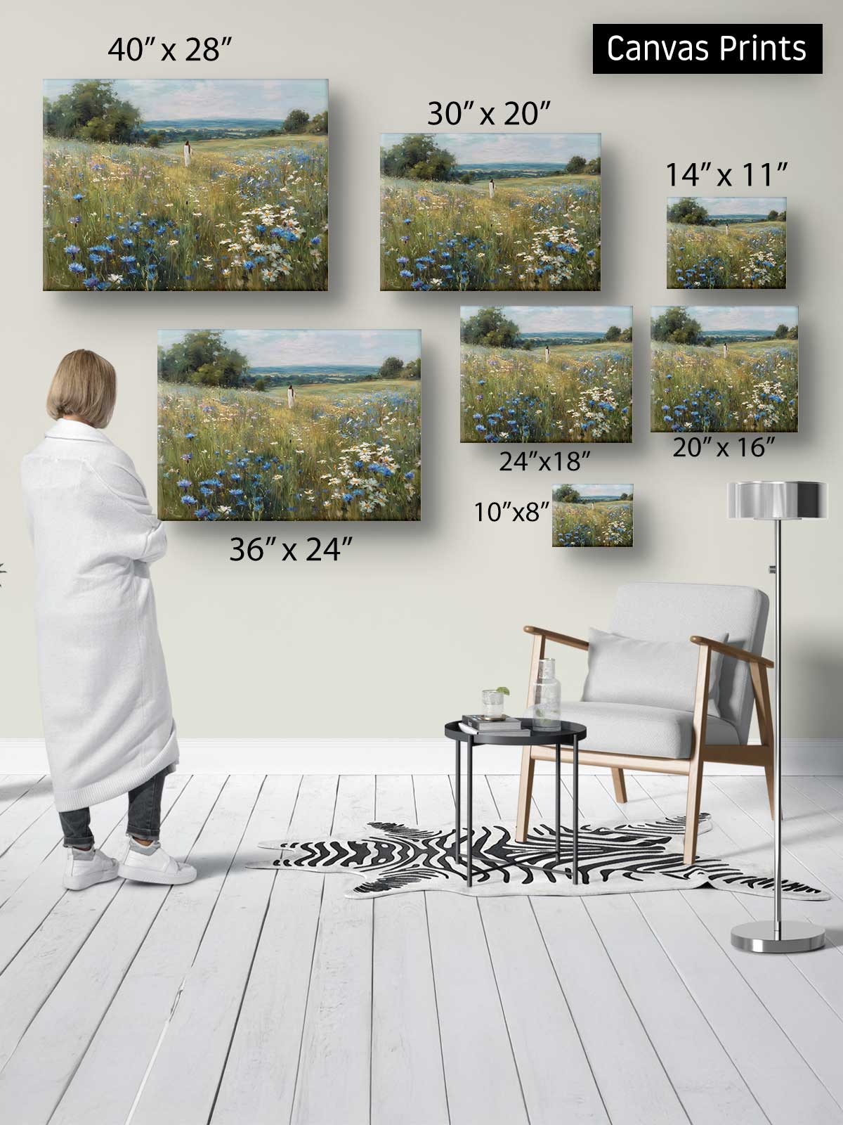 a person standing in a room, surrounded by various sizes of landscape paintings displayed on the wall.