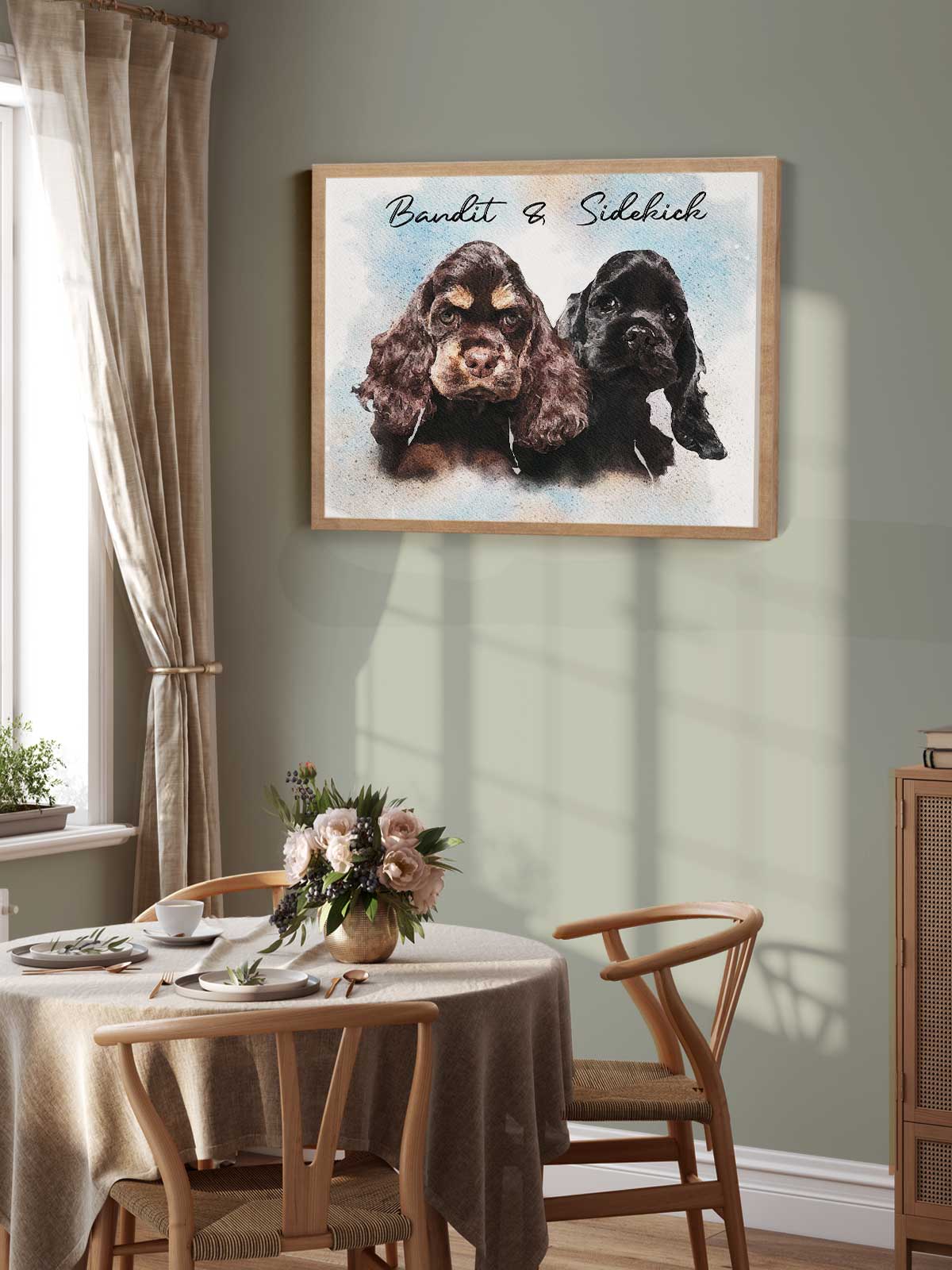 a framed painting of two dogs, one black and one brown, hanging on a wall above a wooden dining table with chairs.