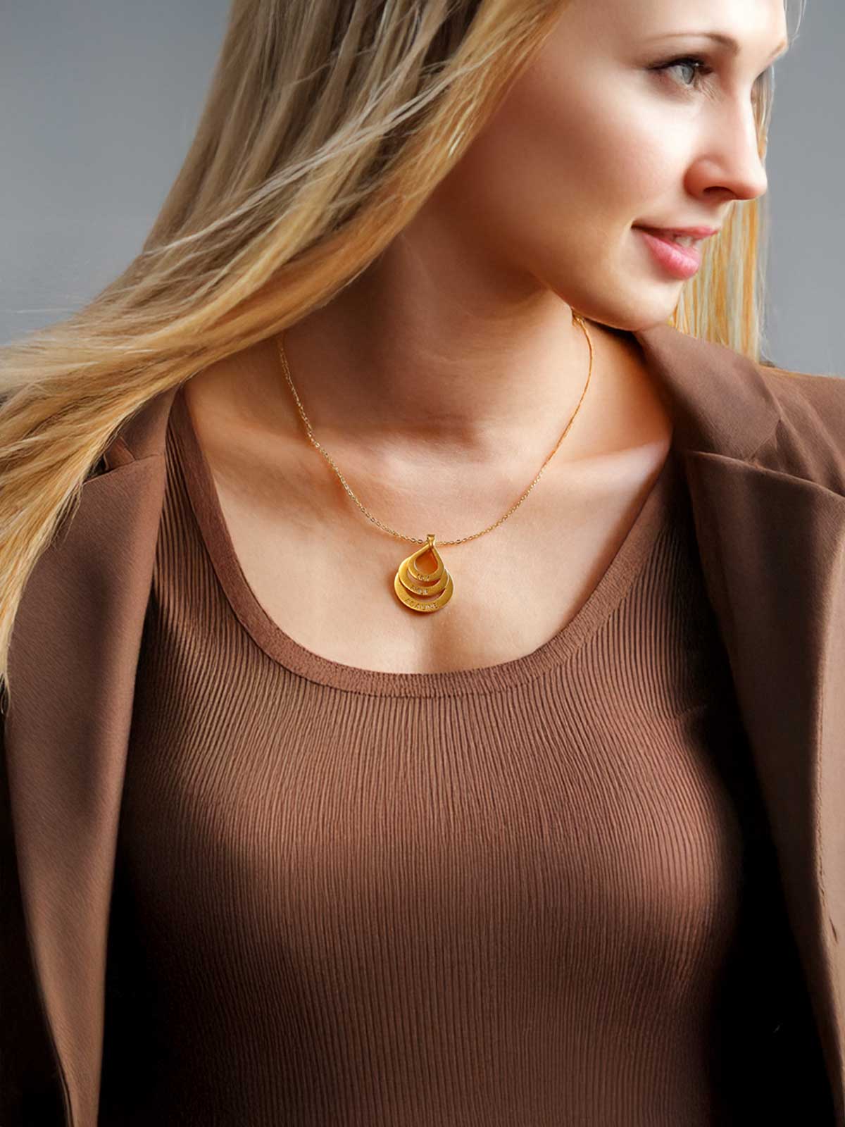 a woman wearing a brown top and a gold necklace