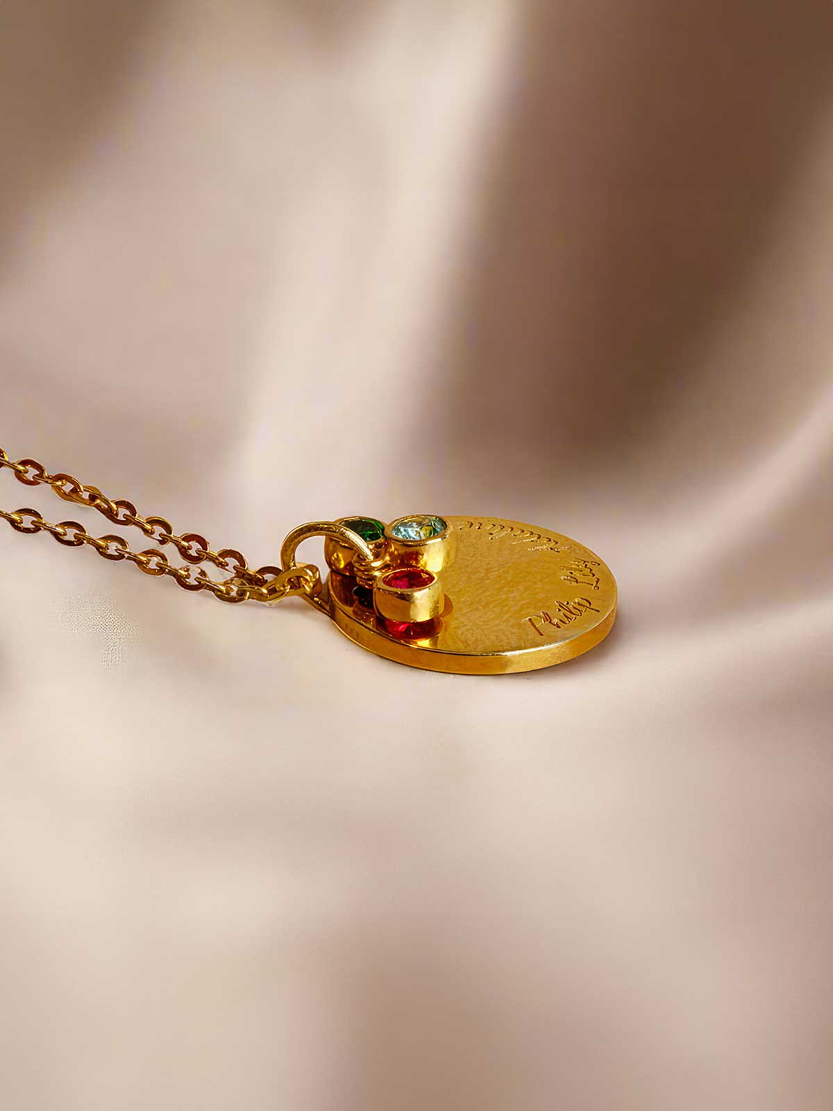 a close up of a gold necklace on a white cloth