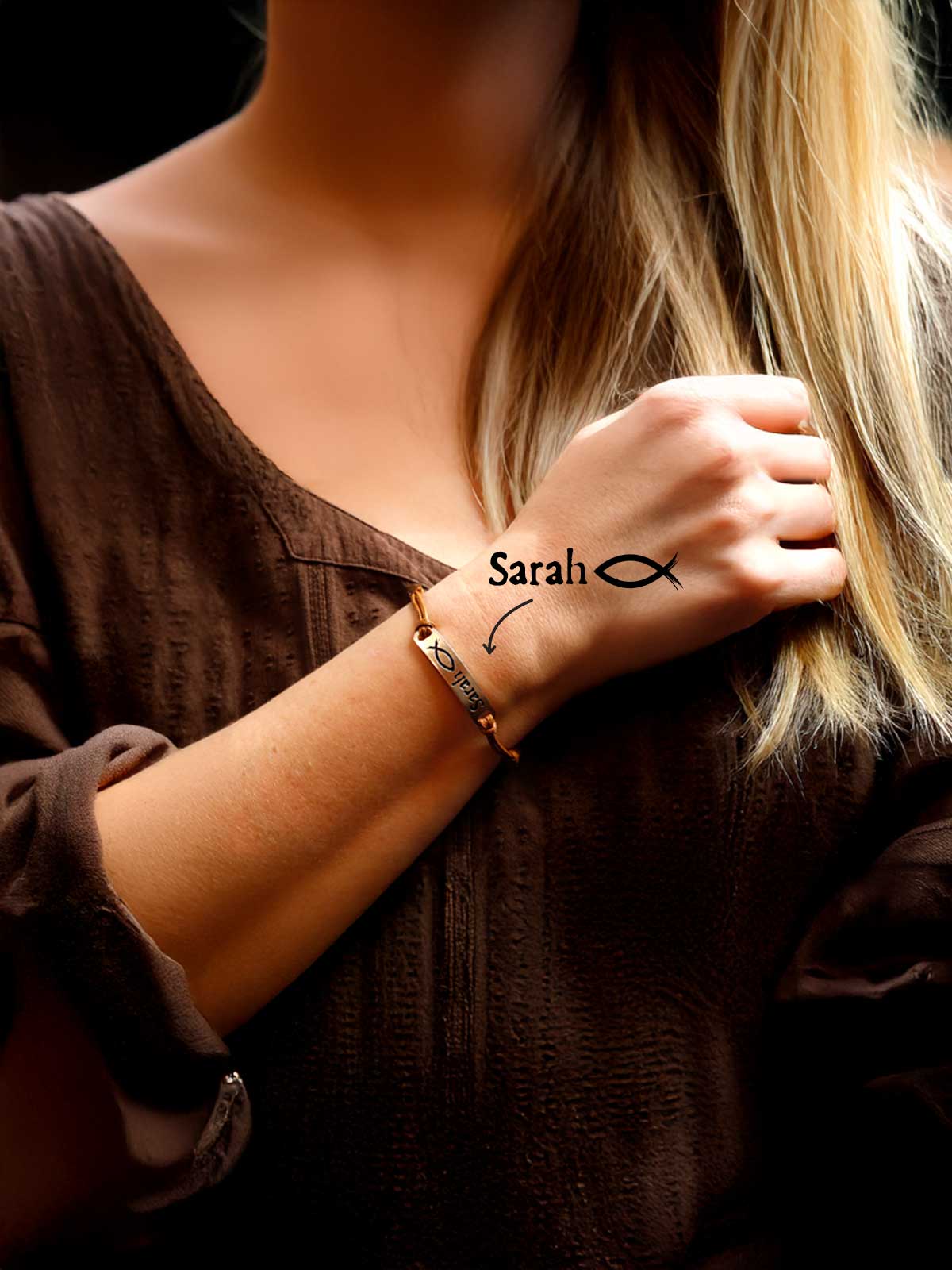 a woman wearing a bracelet with a fish on it