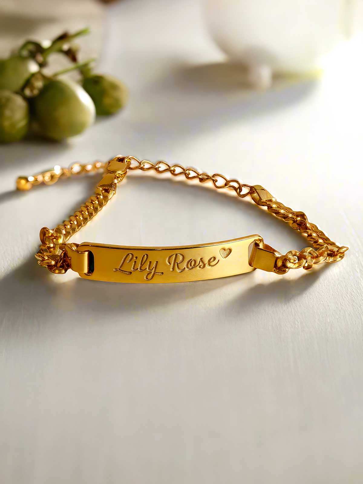 a gold bracelet with a name plate on it