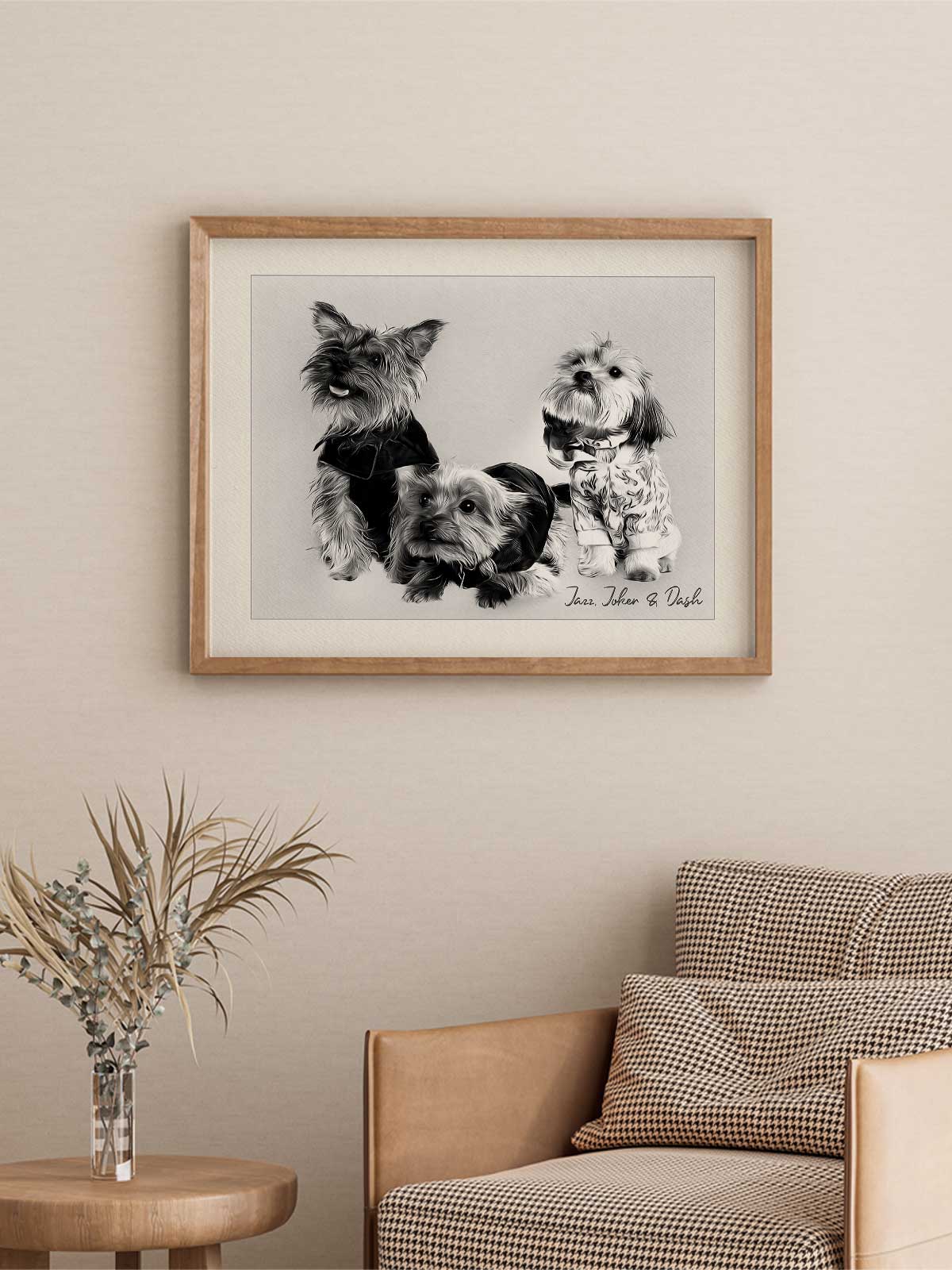 A framed black and white photograph of three dogs is hanging on a wall in a living room setting.