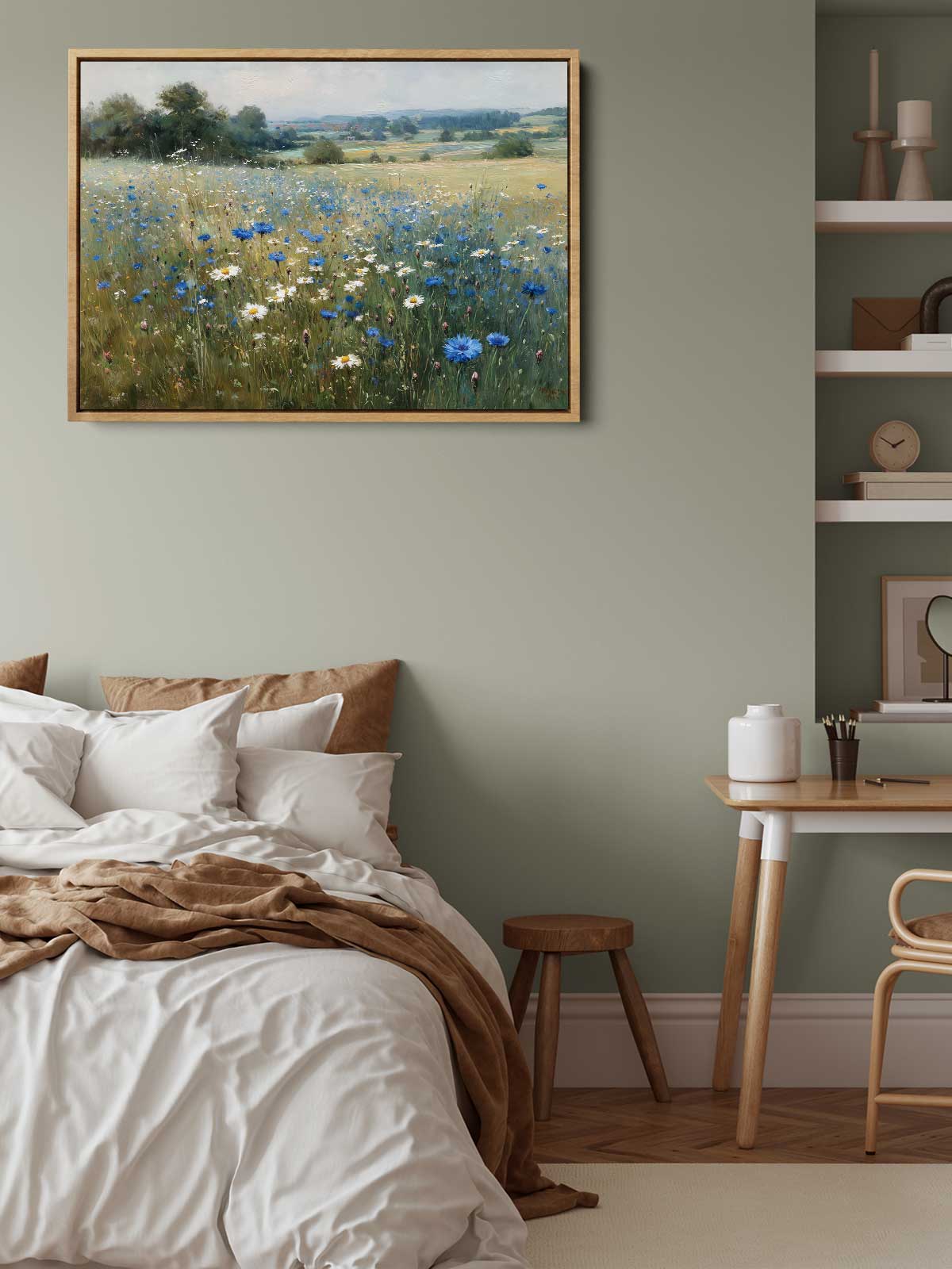 a serene bedroom scene with a bed, a wooden table, and a painting of a field of flowers hanging on the wall.