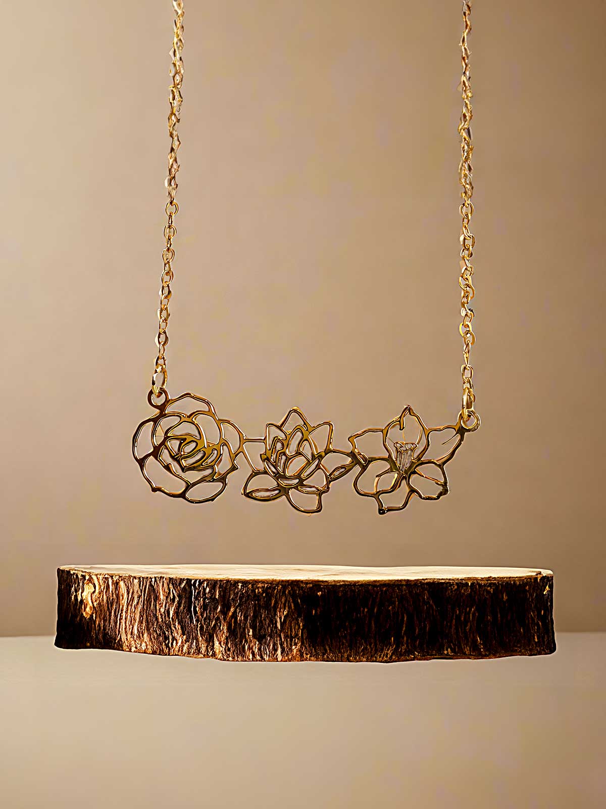 a gold necklace with three flowers on it