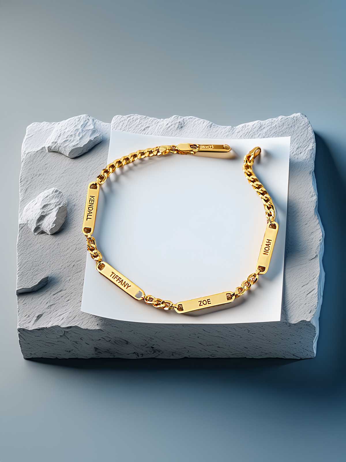 a gold bracelet with two names engraved on it