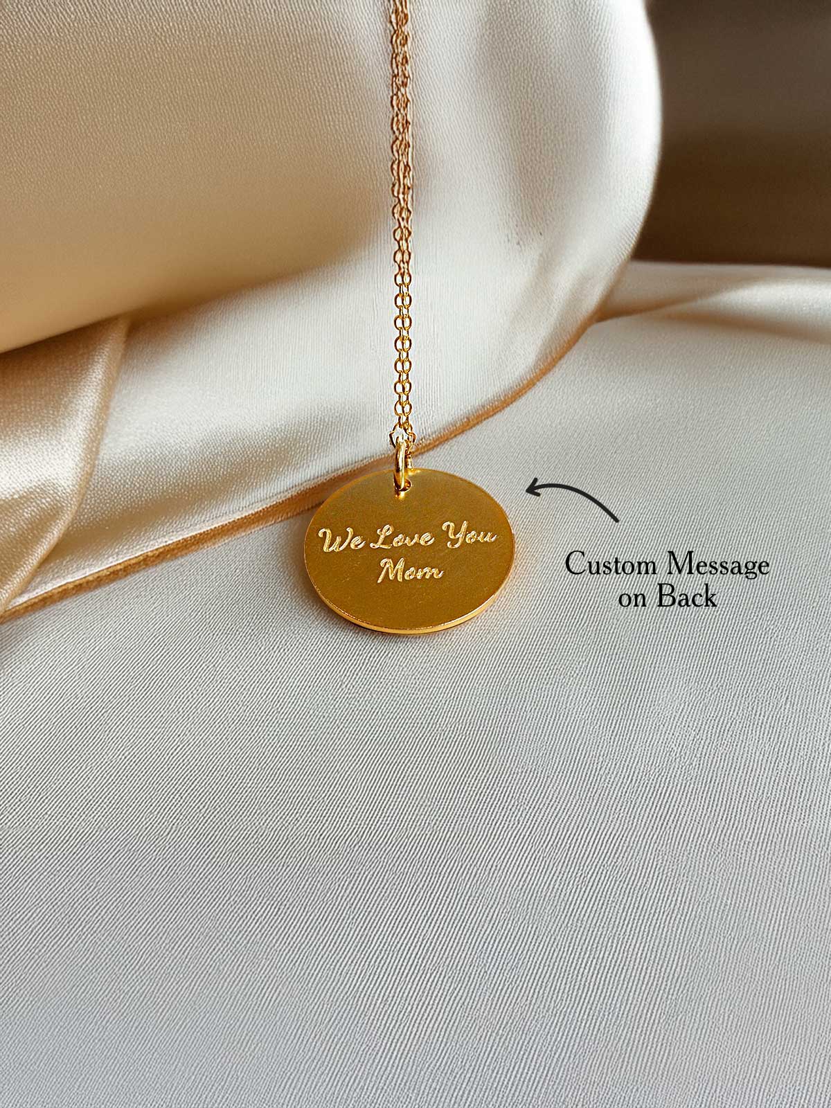 a close up of a gold necklace with a message on it