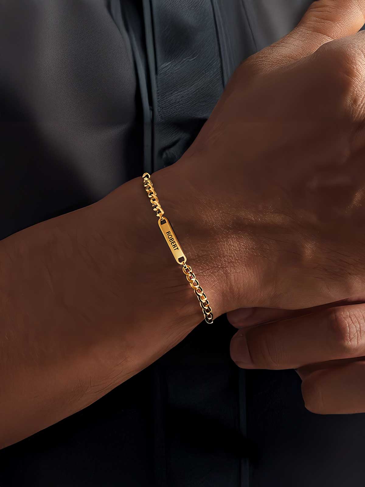 a man wearing a gold bracelet with a chain on it