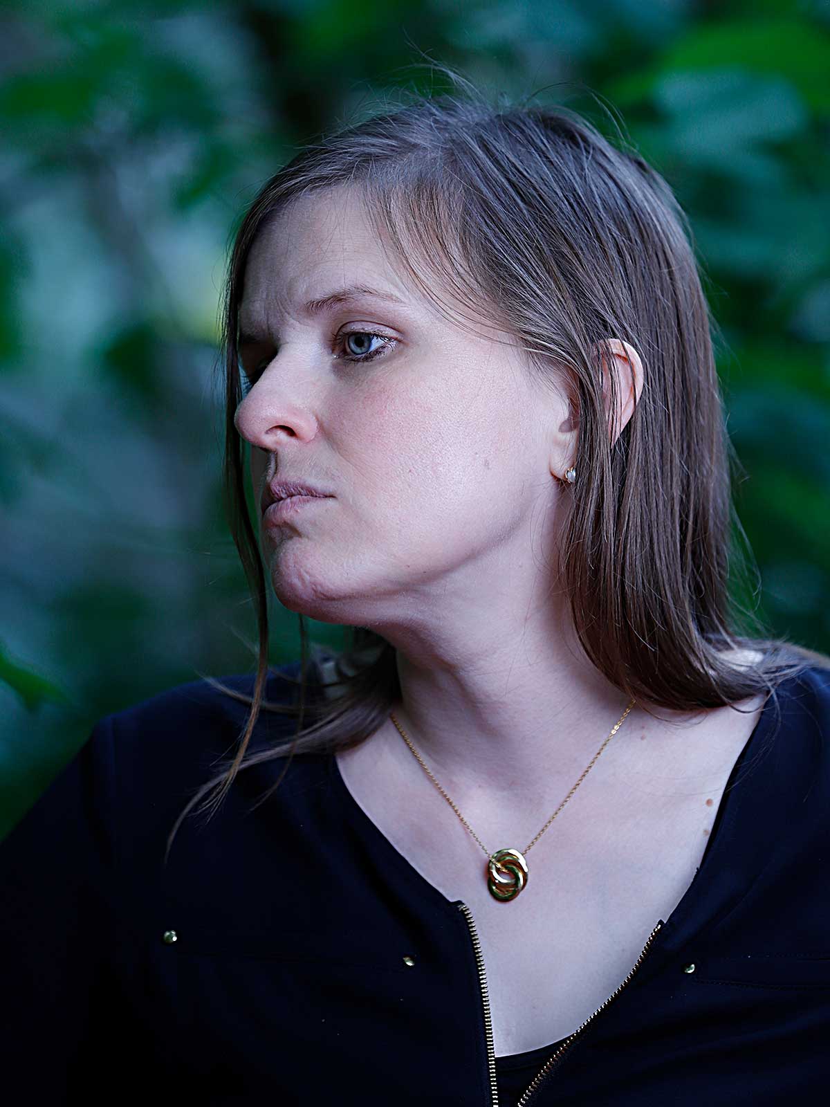 a woman wearing a black shirt and a gold necklace