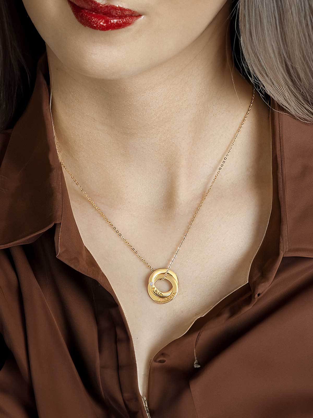 a woman wearing a brown shirt and a gold necklace