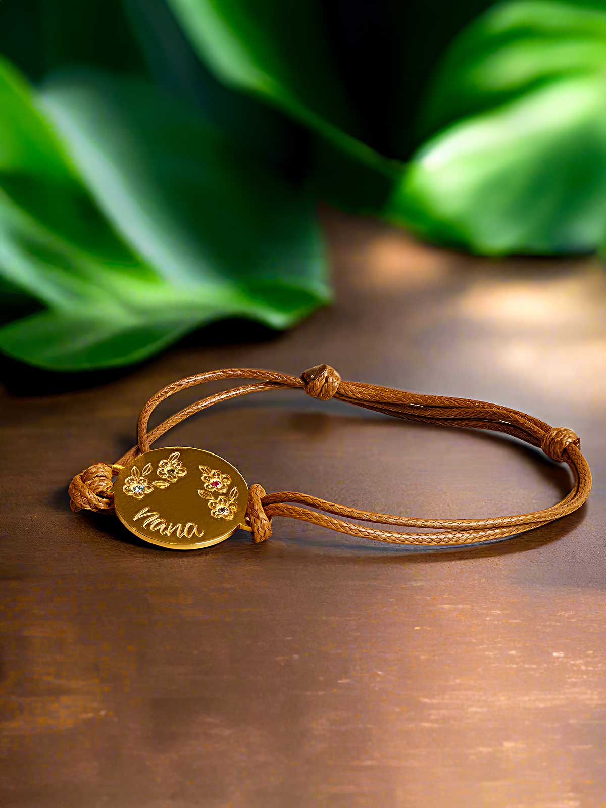 a brown cord bracelet with a gold disc on it