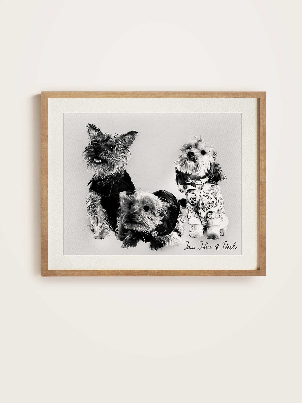 A framed black and white photograph of three small dogs, likely a Yorkshire Terrier, sitting together.