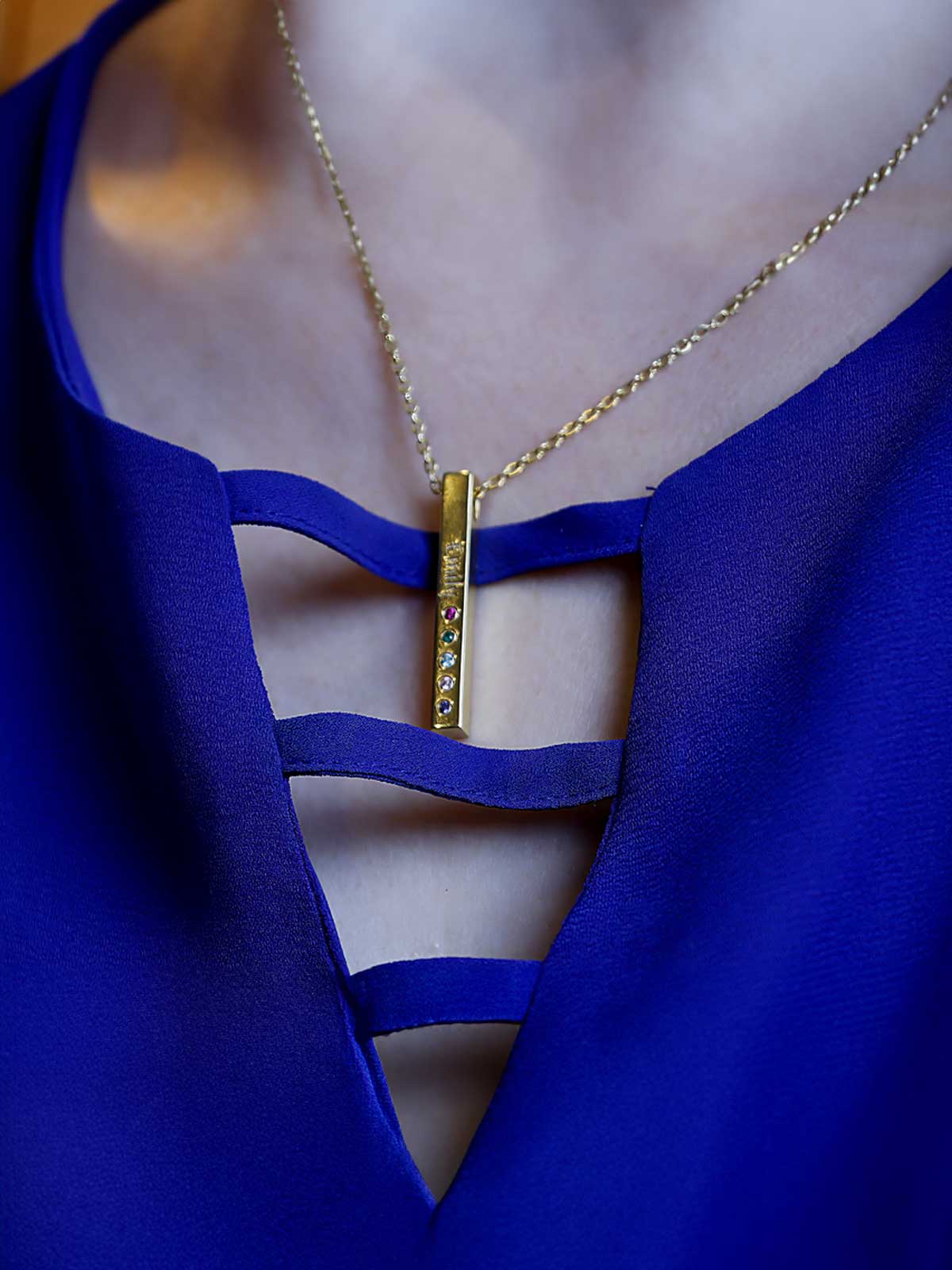 a woman wearing a blue dress and a gold necklace