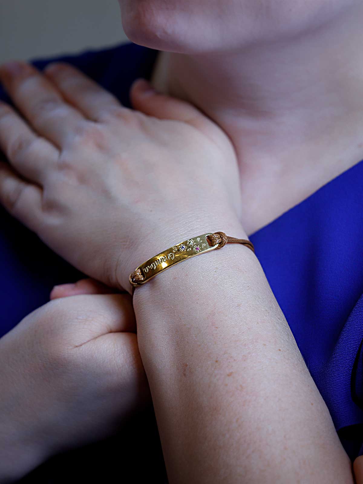 a woman in a blue dress is wearing a gold bracelet