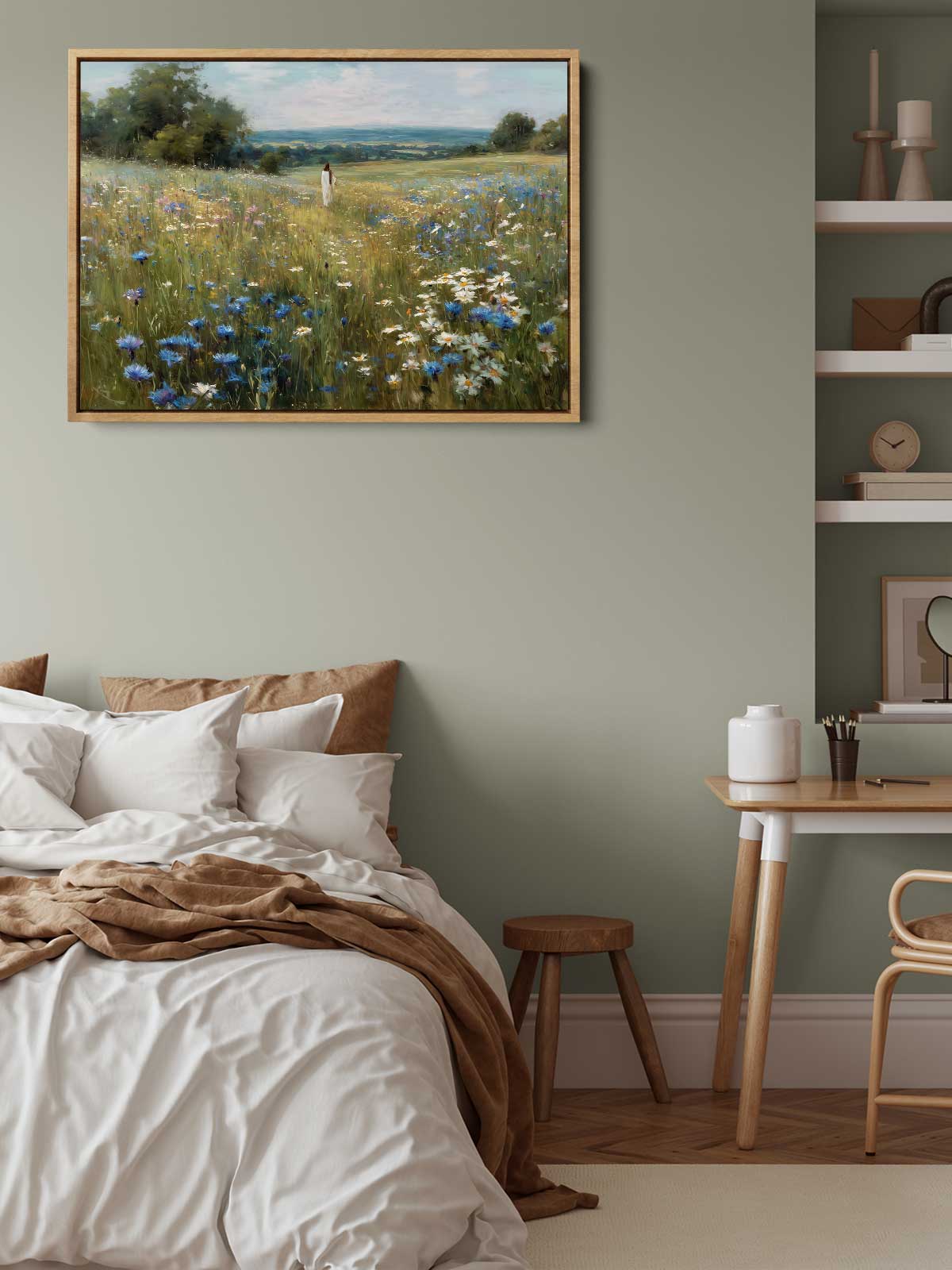 a serene bedroom scene with a bed, a wooden table, and a painting of a field of flowers hanging above it.
