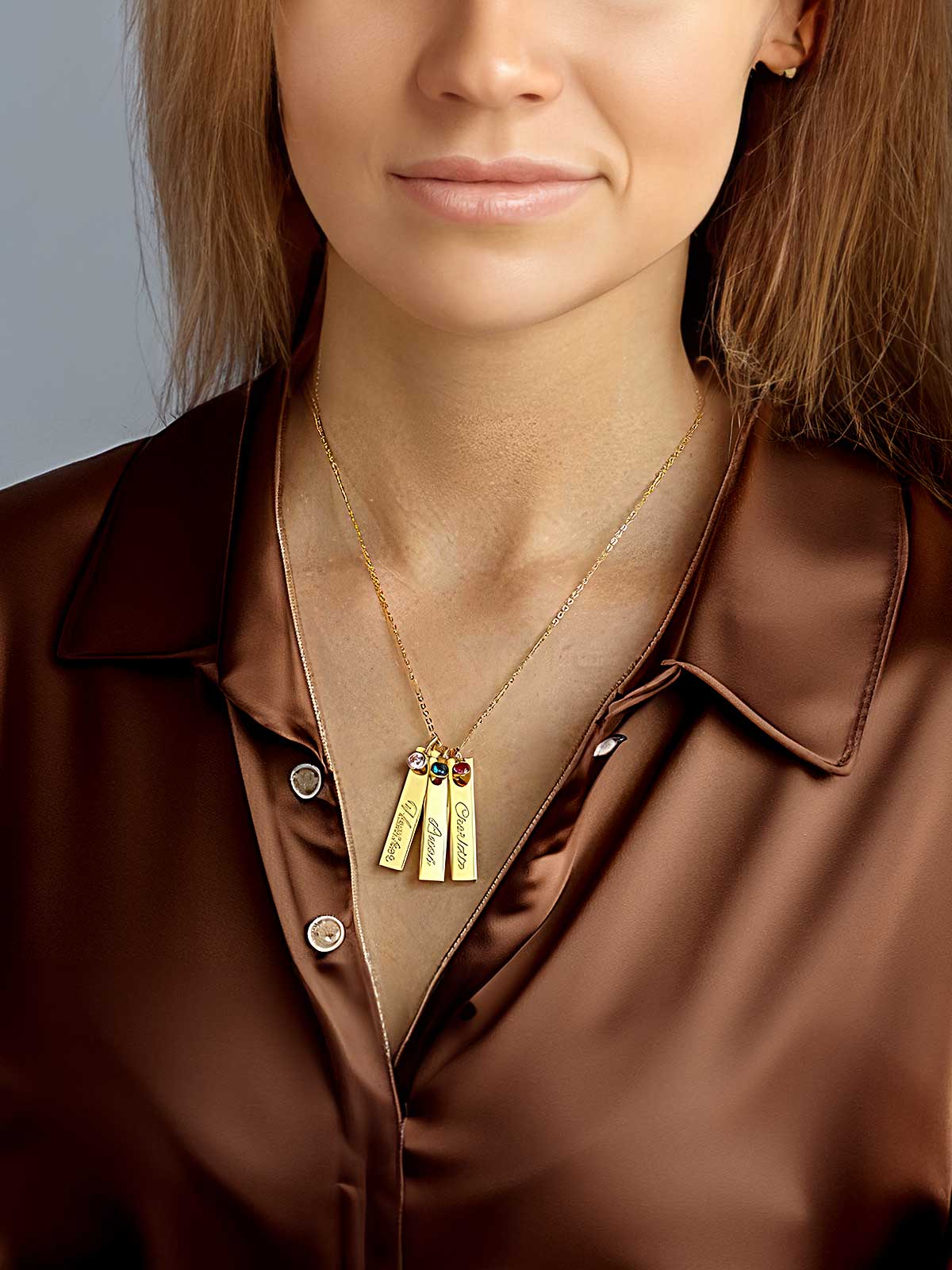 a woman wearing a brown shirt and a gold necklace