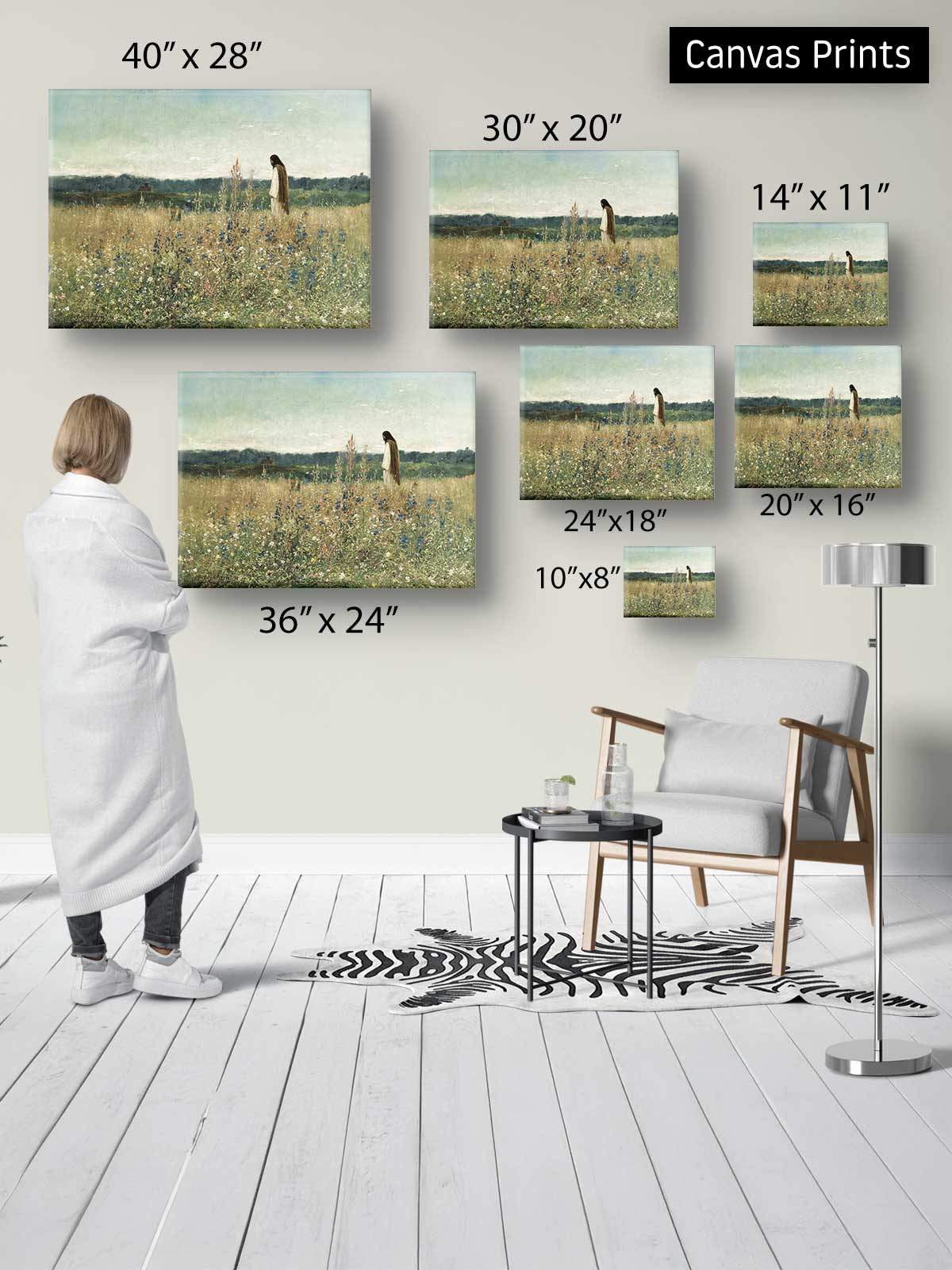 a person standing in a room, surrounded by various sizes of paintings or canvas prints displayed on the wall.