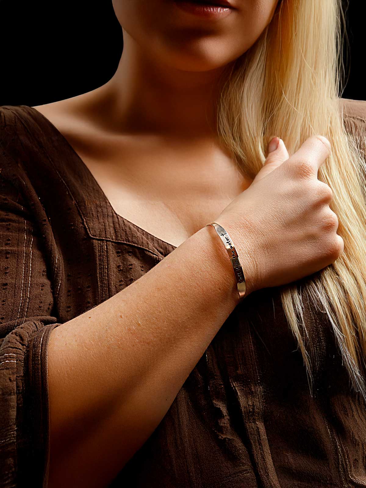 a woman with long blonde hair wearing a bracelet