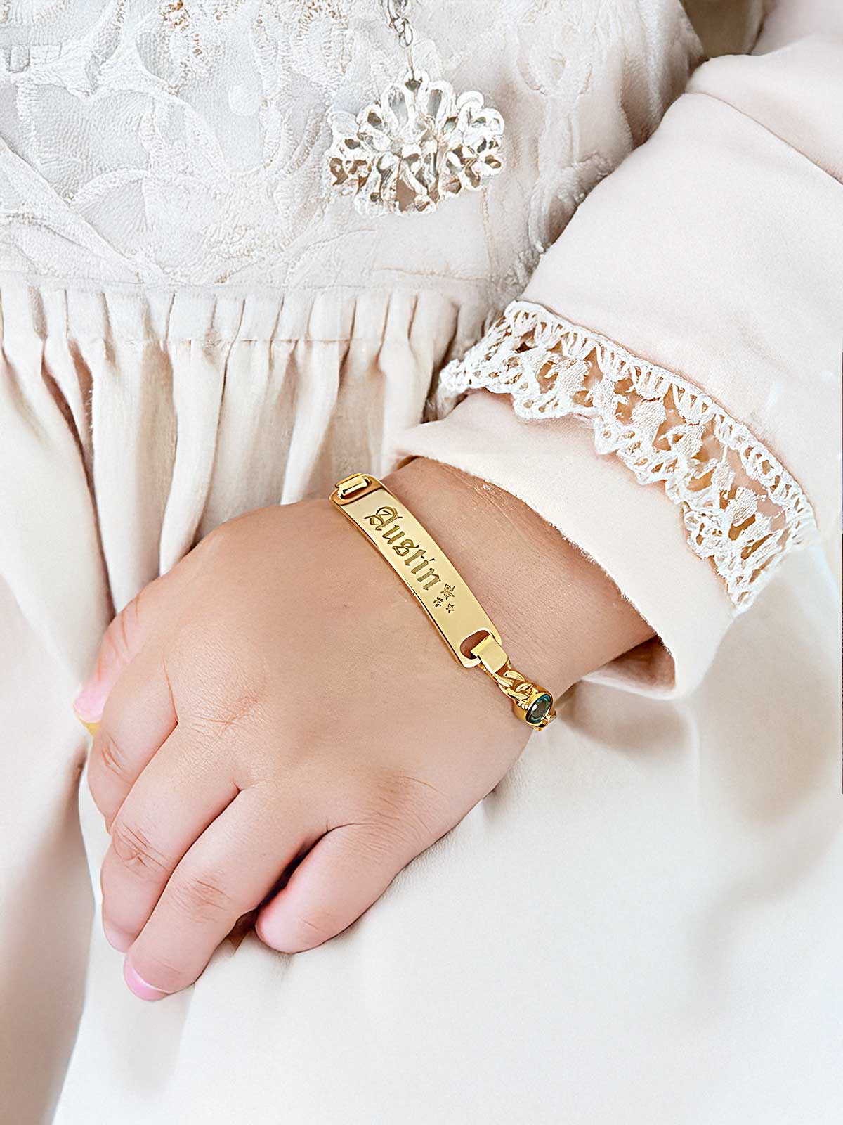 a woman wearing a gold bracelet with a name tag on it