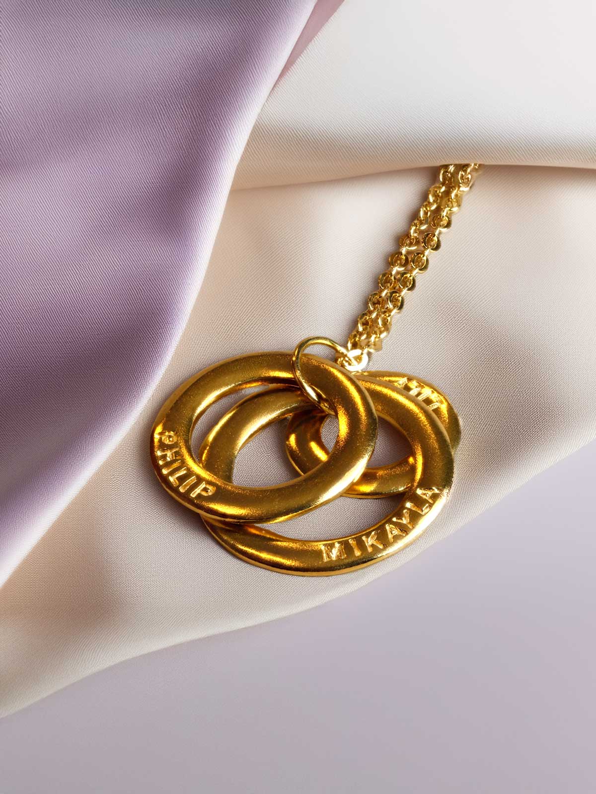 a close up of a gold necklace on a white cloth