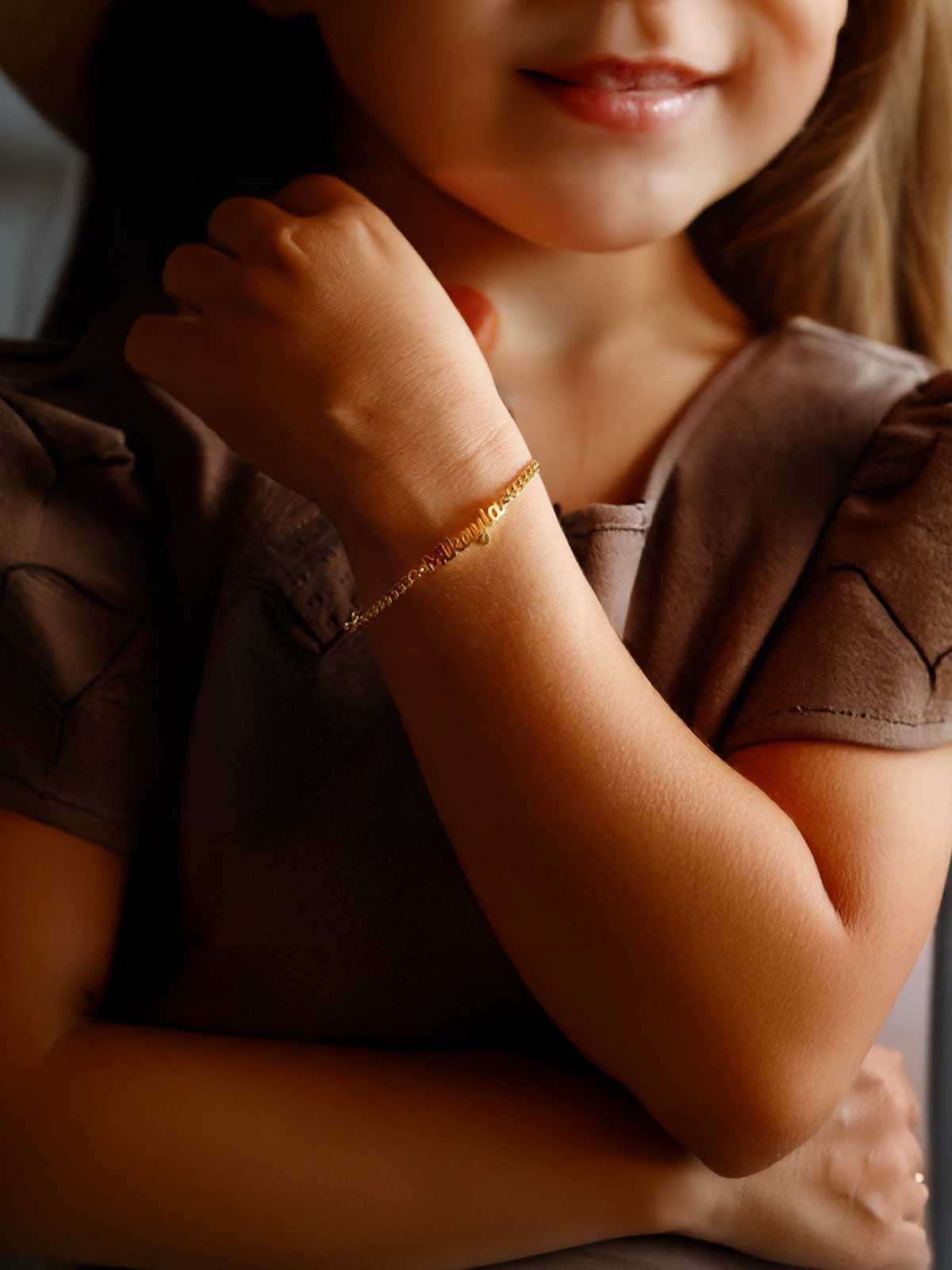 a little girl wearing a brown shirt and a hat