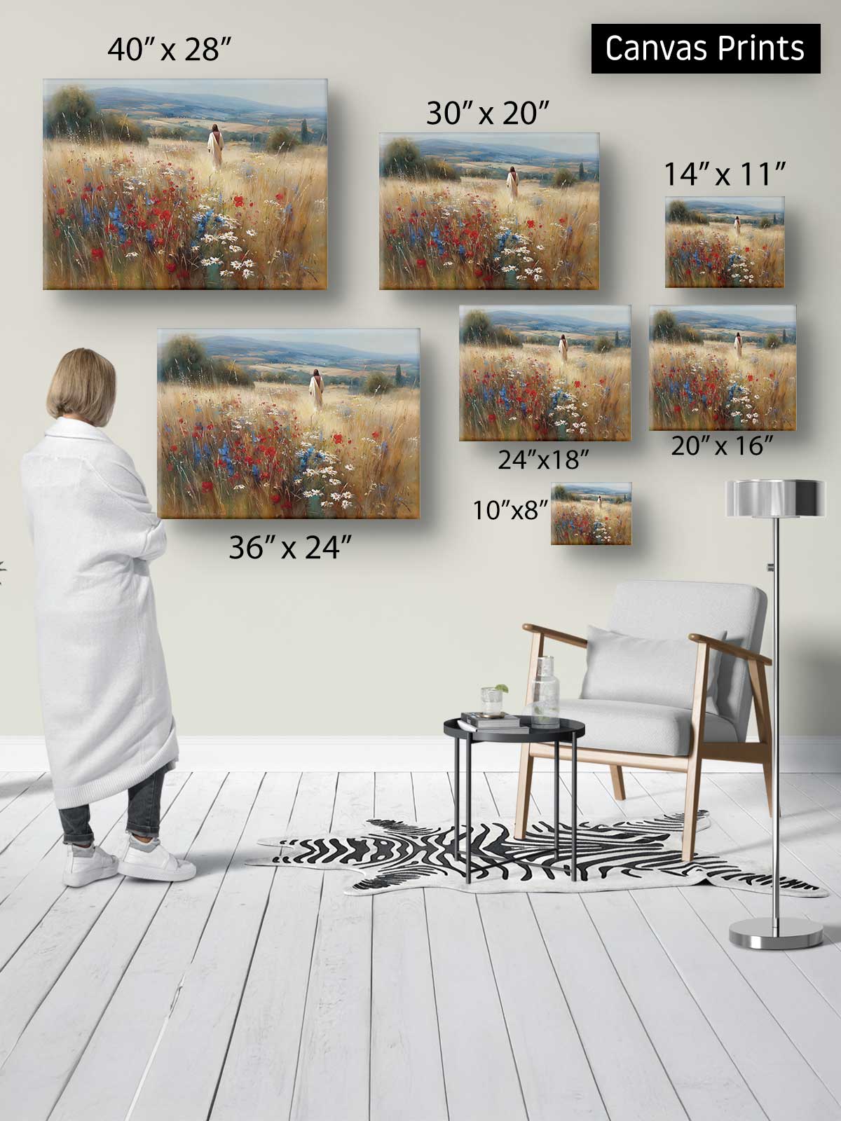 a person standing in a room, surrounded by various sizes of paintings or canvas prints displayed on the wall.