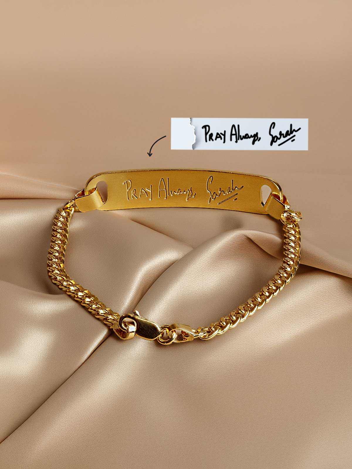 a close up of a gold bracelet with a name tag