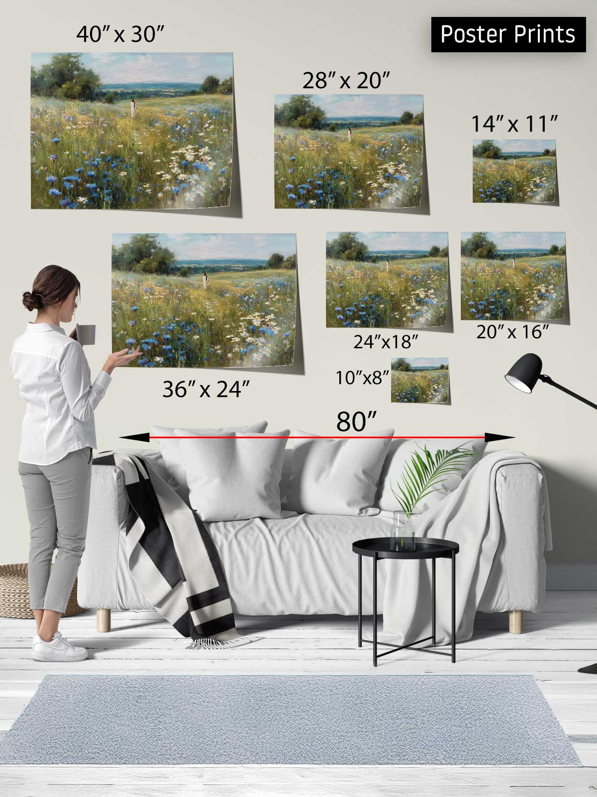 The image is a poster print display featuring a woman standing in front of a couch, with various sizes of landscape paintings arranged above her.