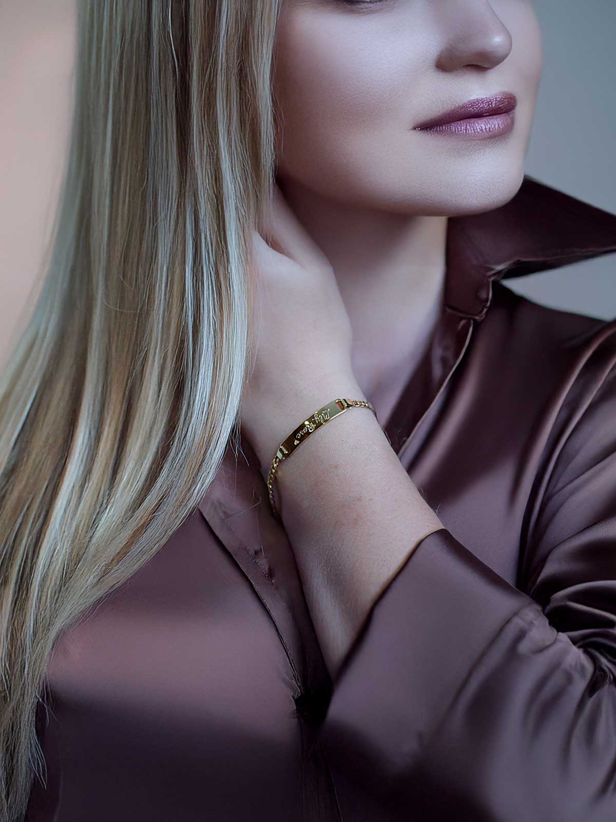 a woman with long blonde hair wearing a gold bracelet