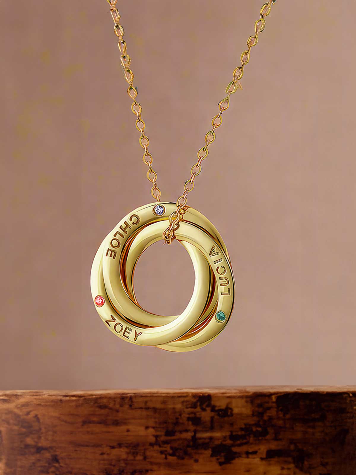 a gold necklace with two interlocked circles on a chain