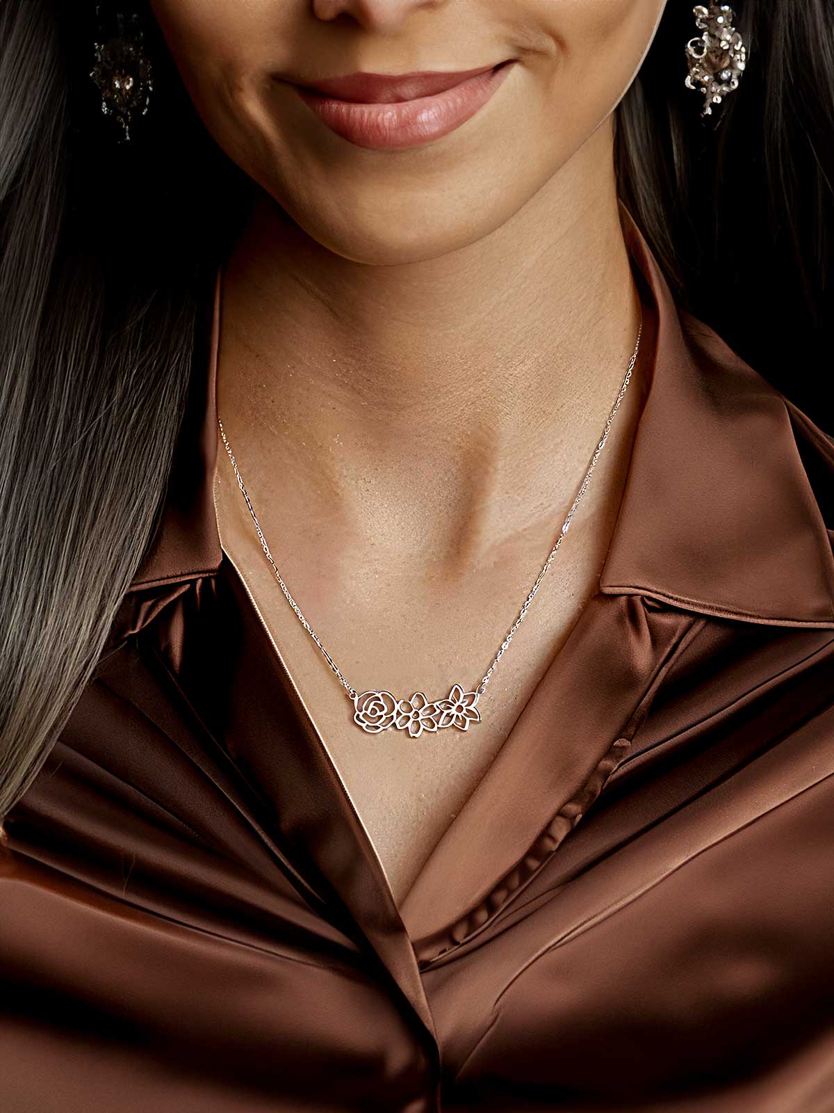 a woman wearing a brown shirt and earrings