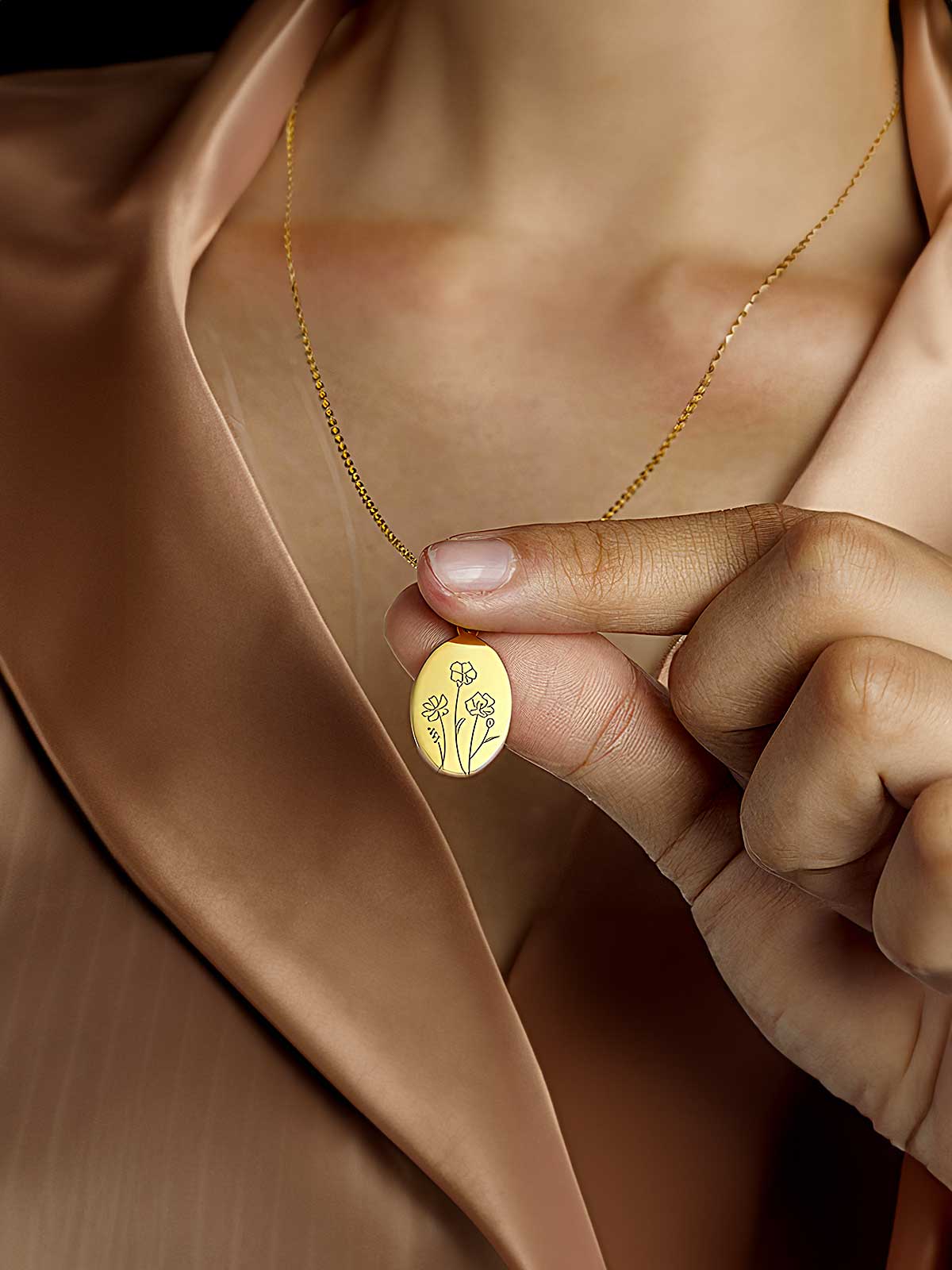 a woman wearing a gold necklace with a flower on it